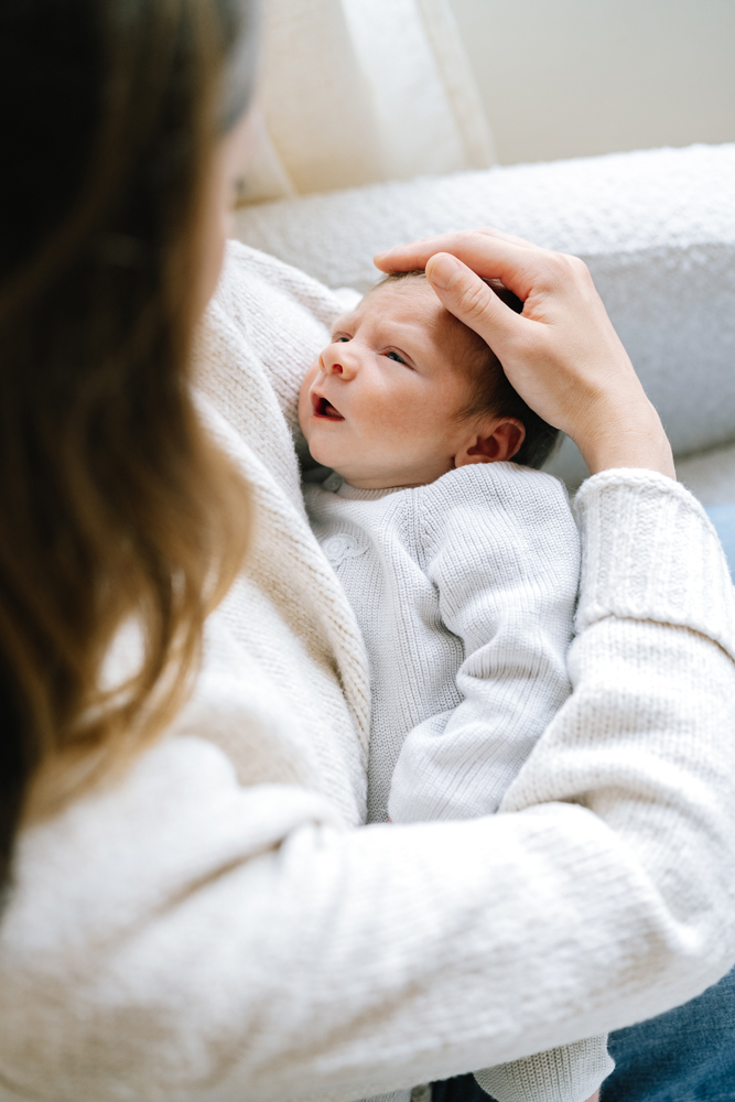 Overhead photo of newborn lying on cream blanket