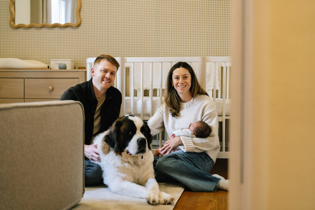 Family with newborn and dog in cozy nursery