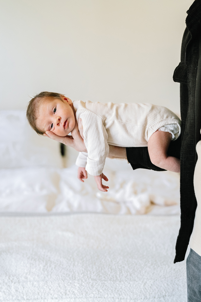 Baby lying on bed in softly lit bedroom