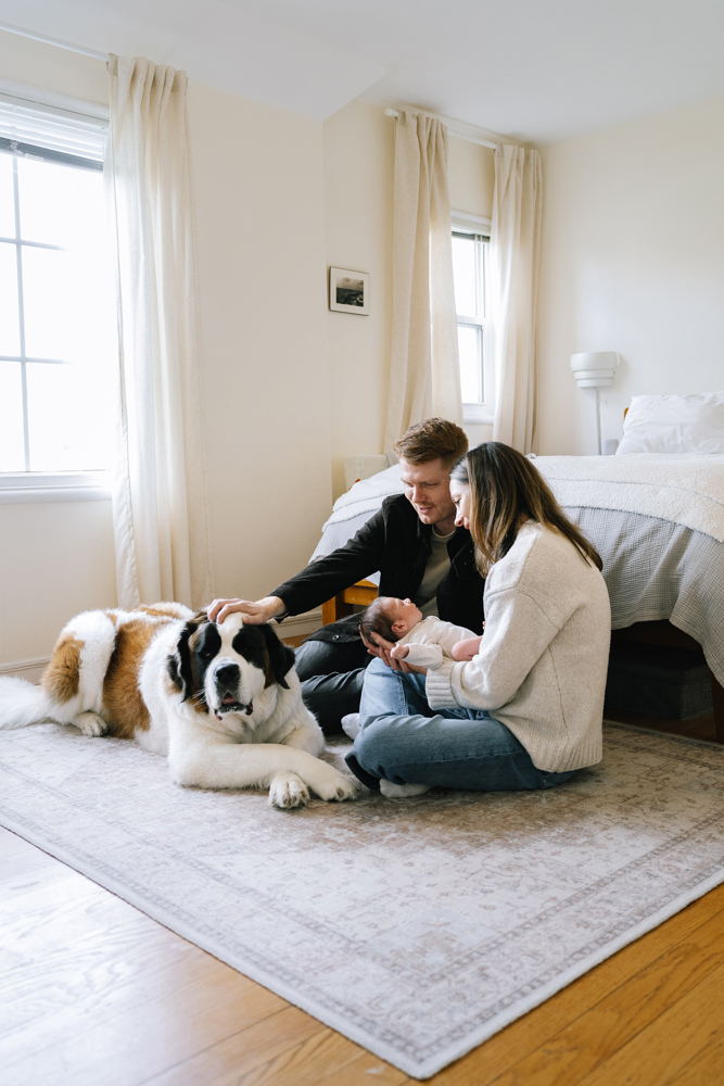Family cuddling on rug during in-home newborn session