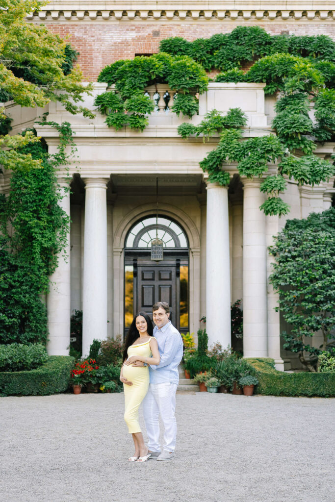 Family photographer Villa Montalvo Saratoga — couple kissing on lawn with Mediterranean villa in background