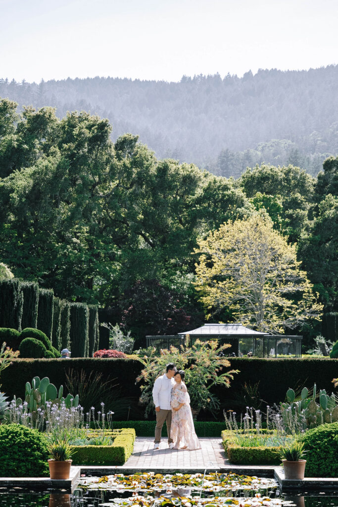 Maternity session at Filoli Historic Garden Woodside Bay Area — couple in formal garden with manicured hedges and forested hills