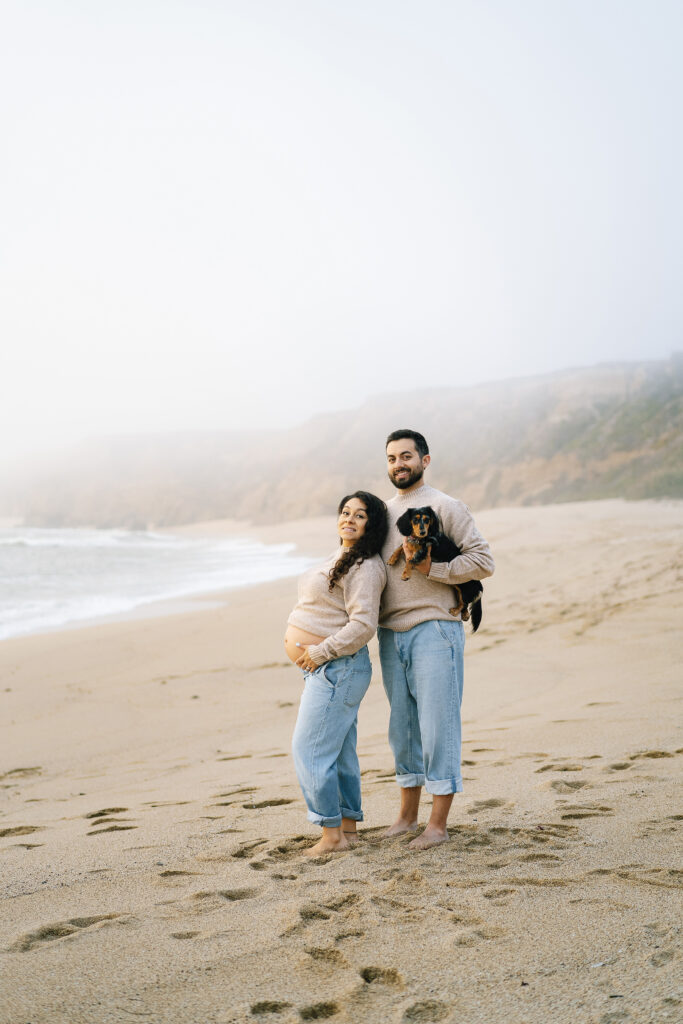 Maternity session at Half Moon Bay — couple with dog on sandy beach Bay Area