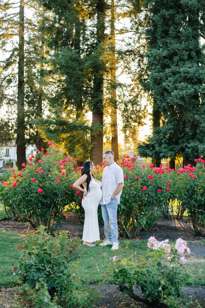 Maternity session at Municipal Rose Garden San Jose — couple standing among blooming roses at golden hour